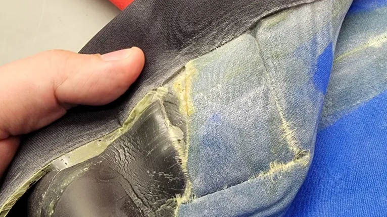 A close-up of part of a survival suit showing a seam separating