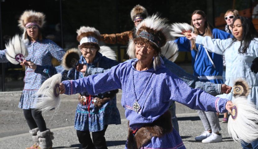Women and girls, some in traditional dress, dancing