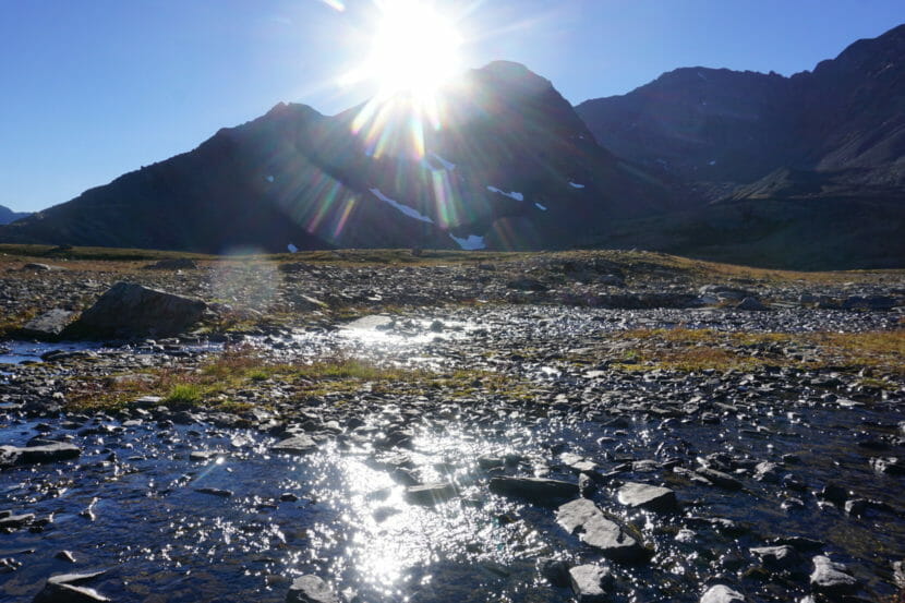 Sun beating down over the mountains on uplands stream