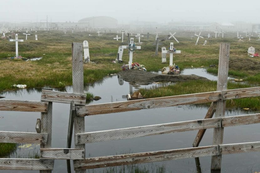 A cemetery in the fog, with standing water encroaching