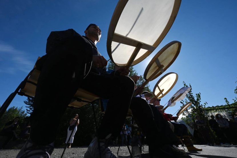A row of seated men playing skin drums
