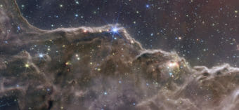 The bottom half of the image is taken up by a billowing nebula with stars shining through it