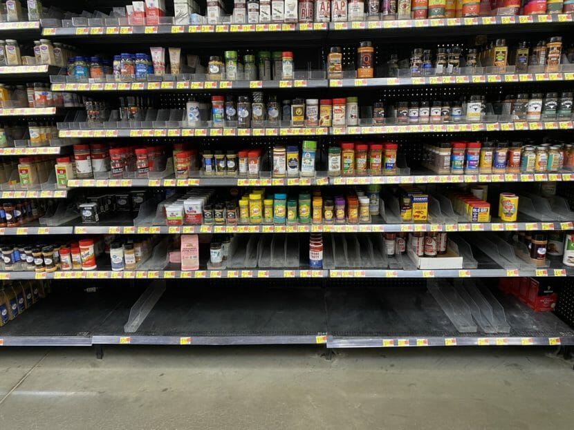 Grocery store shelves with numerous spices missing and no salt at all