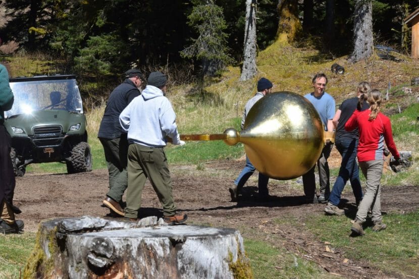 Several people carrying a gold dome for the top of a chapel