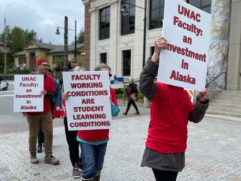 Picketers in red wear signs supporting the faculty union
