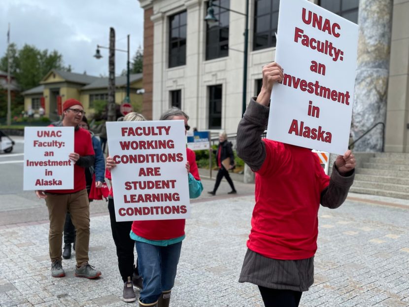 Picketers in red wear signs supporting the faculty union