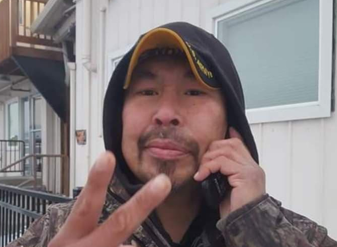 A man in a baseball cap talking on a phone