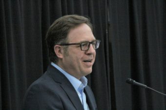 A man in a suit speaking into a microphone