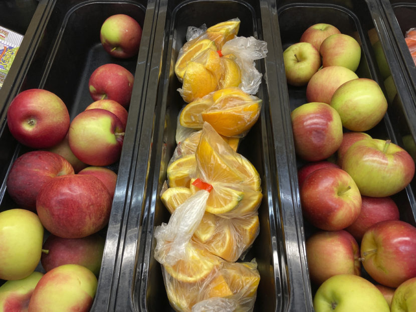 bins of apples and sliced oranges