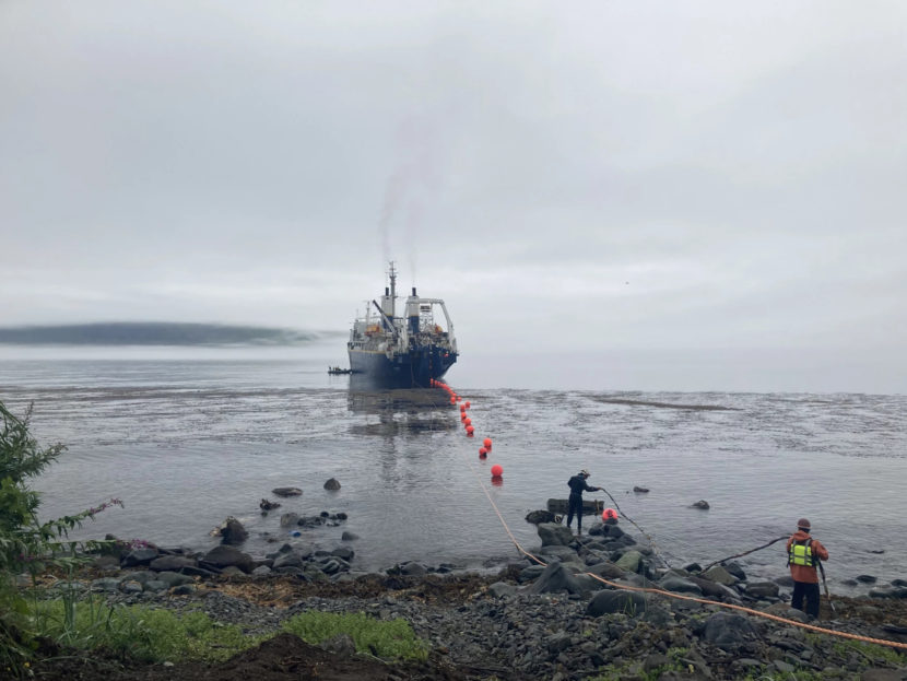 A ship leaving Unalaska dragging a heavy cable behind it