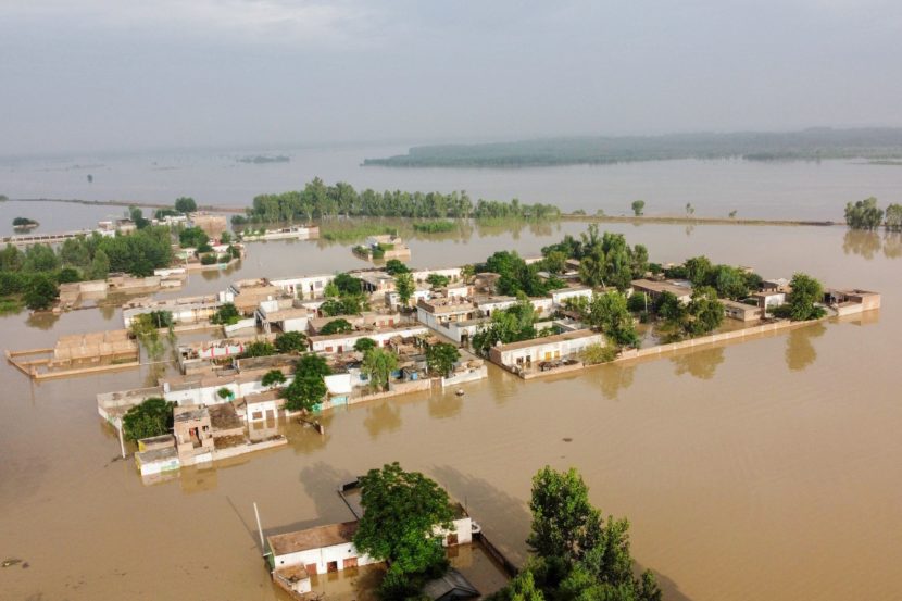 An aerial photo of a large neighborhood that is completely flooded, with muddy water all around and far into the distance