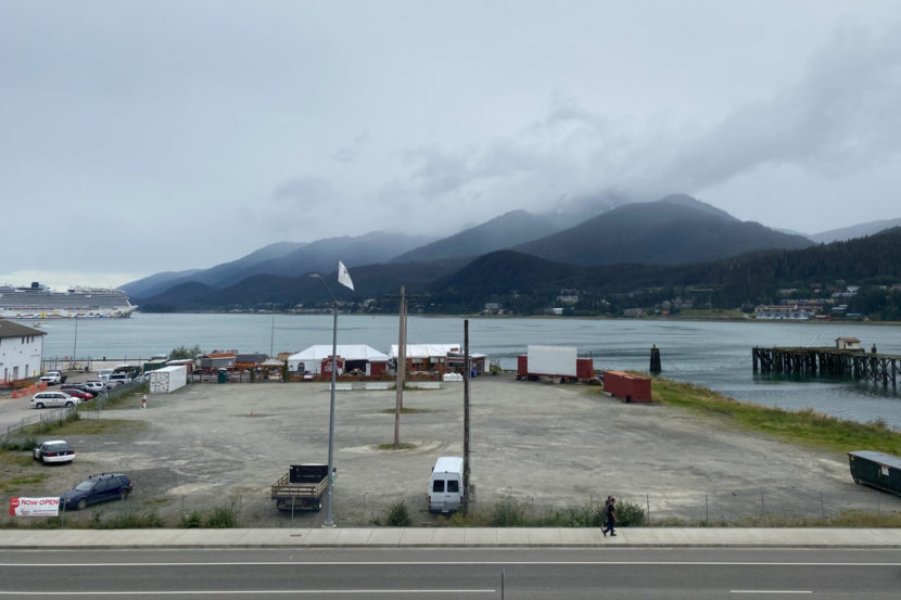 A large, mostly empty waterfront lot with Gastineau Channel in the background