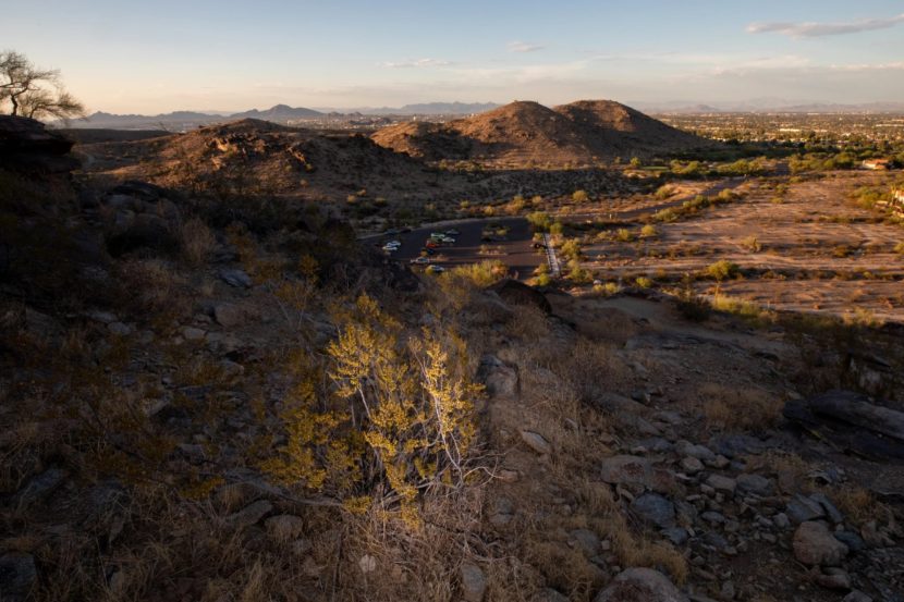 A desert landscape with a parking lot below