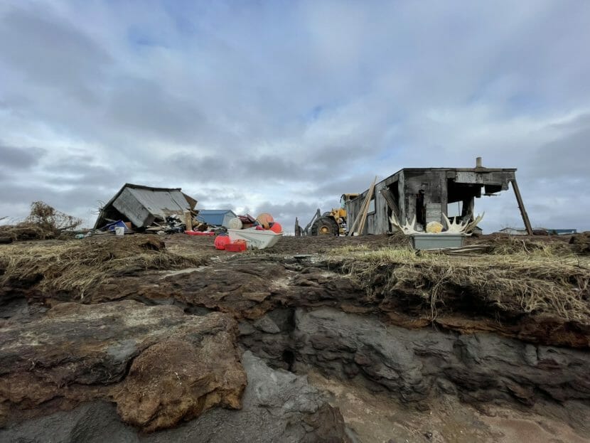 Two buildings at a fish camp, one badly damaged and the other knocked over