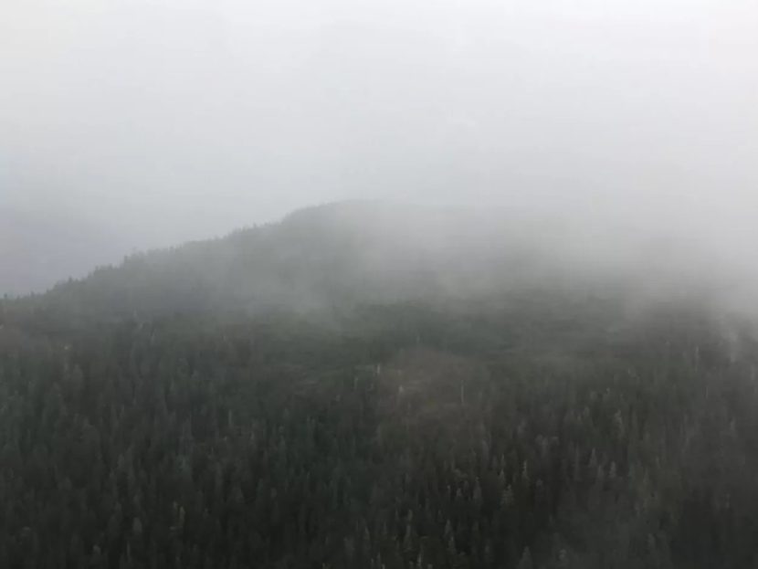 A hilltop obscured by fog, seen from a plane
