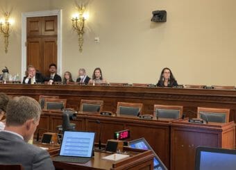 Mary Peltola sits listening in a committee room that has many empty seats