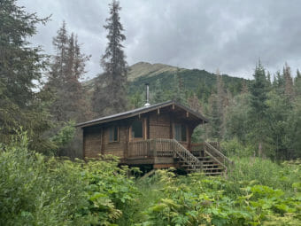 A cabin with a mountain behind it