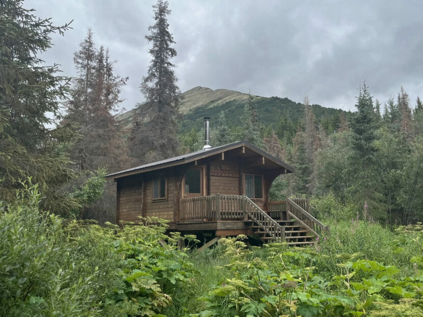 A cabin with a mountain behind it