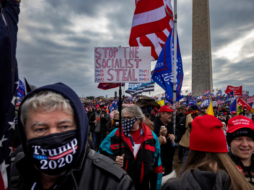 Protestors in Washington on Jan. 6, 2021, one of them waving a sign falsely claiming the election was stolen.