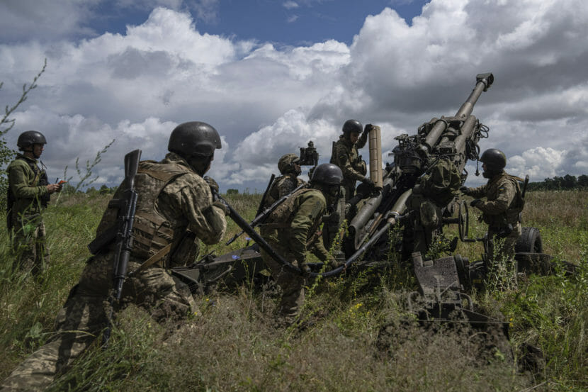 Soldiers in uniform operating a large field gun