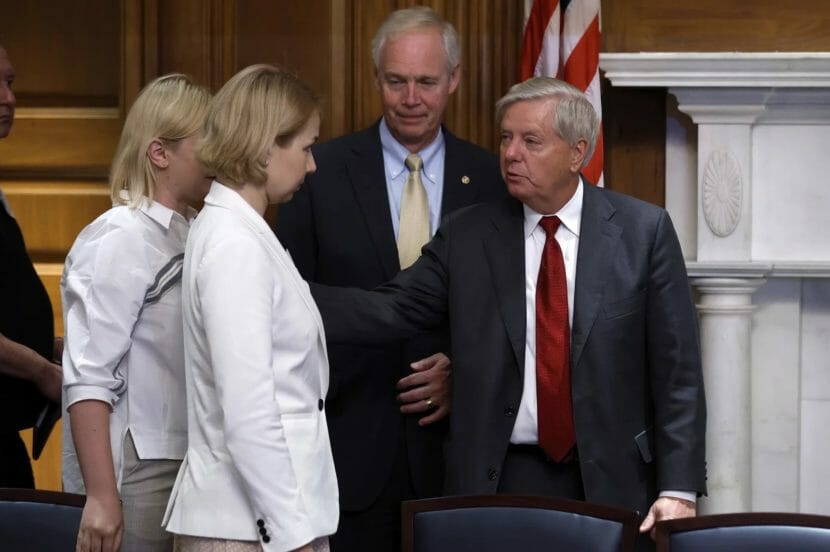 Two women speaking to Sens. Ron Johnson and Lindsay Graham