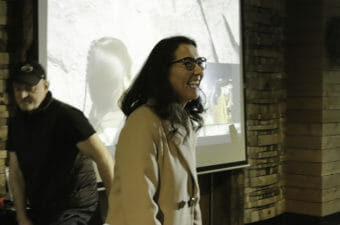 Mary Peltola, laughing, walks in front of a large screen.