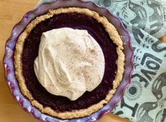 A purple pie, seen from above, with a circle of cream covering most of it