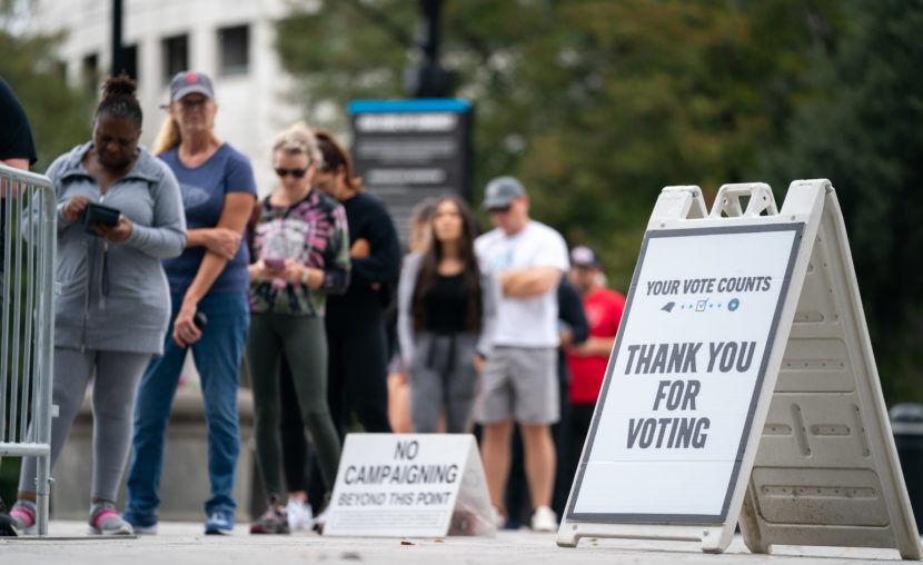 People stand in line at a polling place