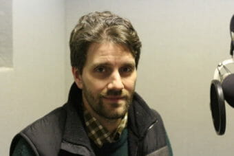 A man sitting by a microphone