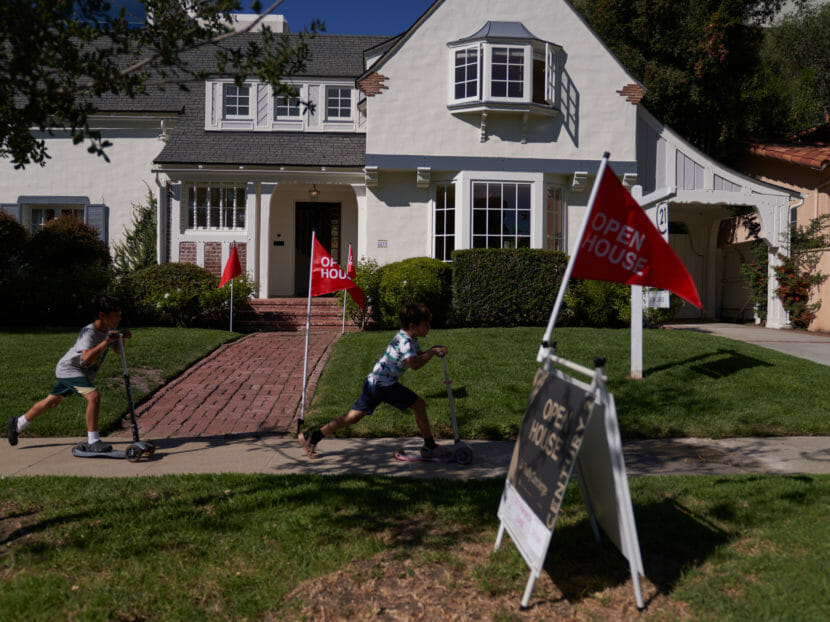 A house for sale with signs for an open house in front of it