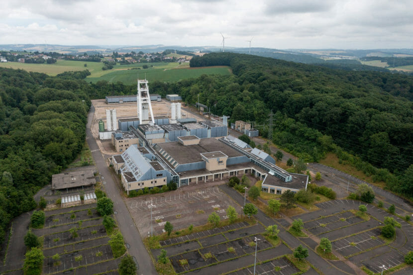 An aerial photo of a coal mine in a clearing in a forest.