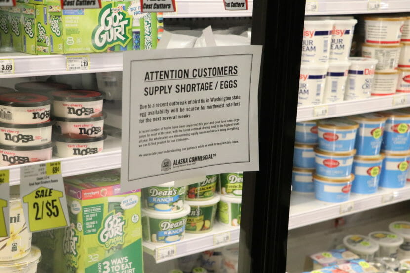 A sign on a glass refrigerator door telling customers there is a shortage of eggs