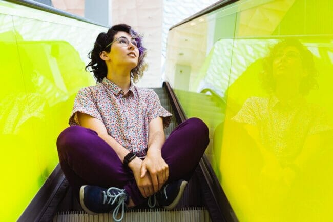 Molly Lewis sitting on the escalator at the Seattle Central Library