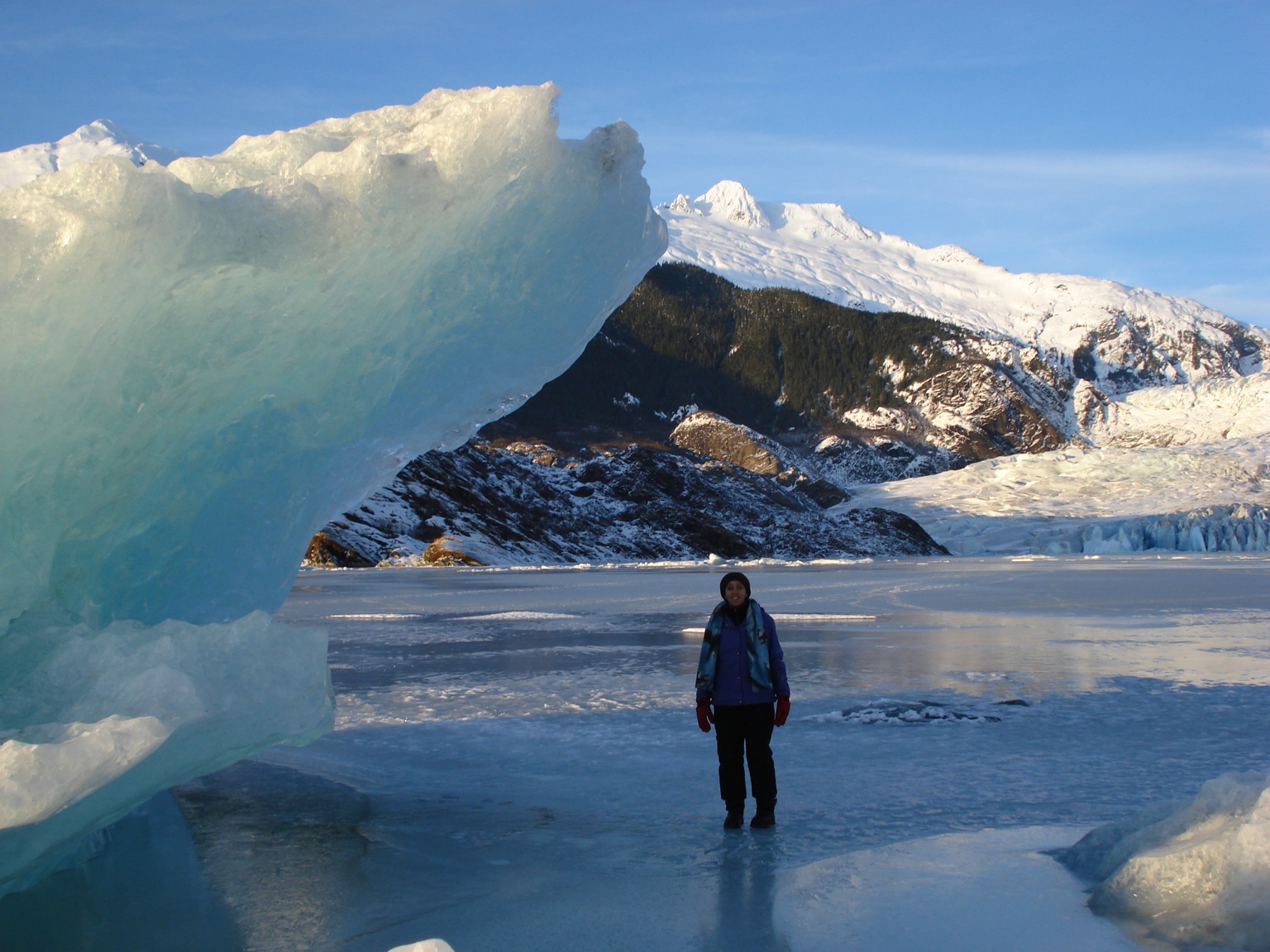 Haben Girma stands next to an iceberg jutting over her head near the Mendenhall Glacier in Juneau, Alaska.
