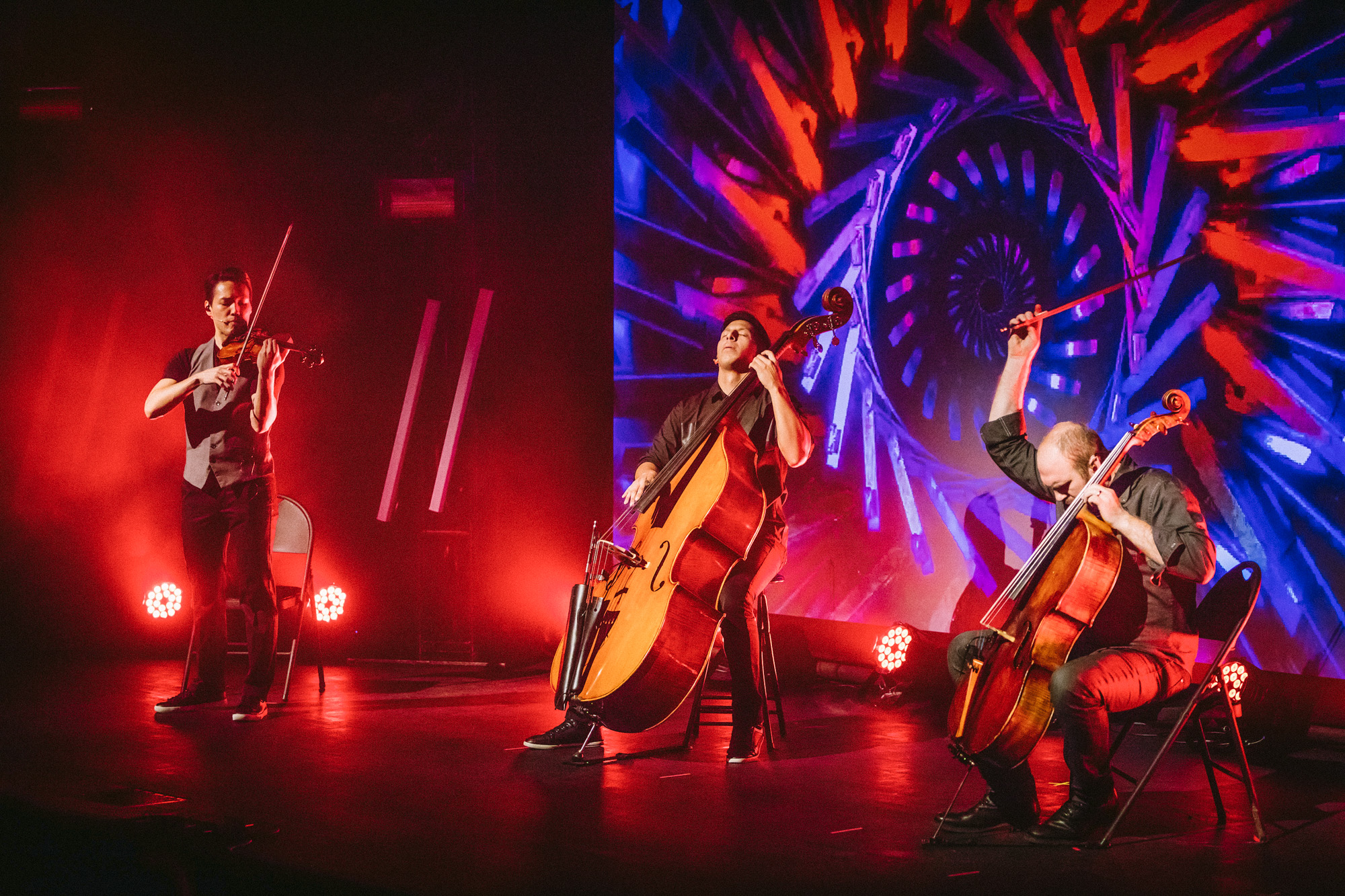 Simply Three in live performance surrounded by colorful lights