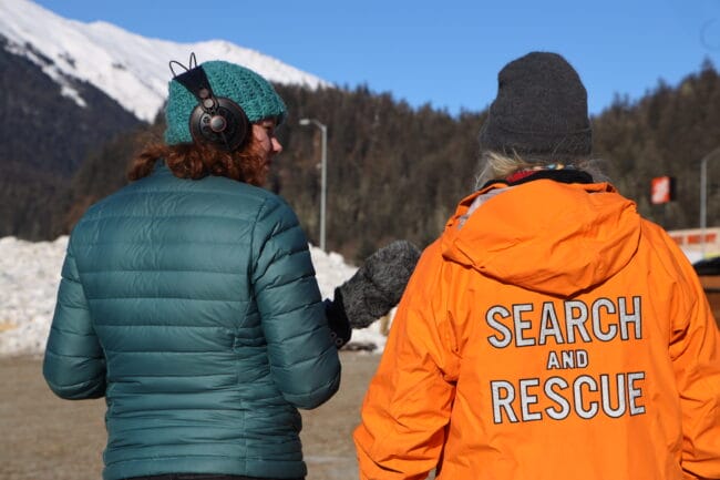 KTOO Climate Reporter Anna Canny interviewing a member of a local search and rescue team.