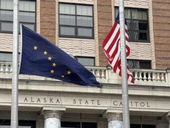 The Alaska and American flags fly in front of the Alaska State Capitol on Tuesday, April 22, 2025.
