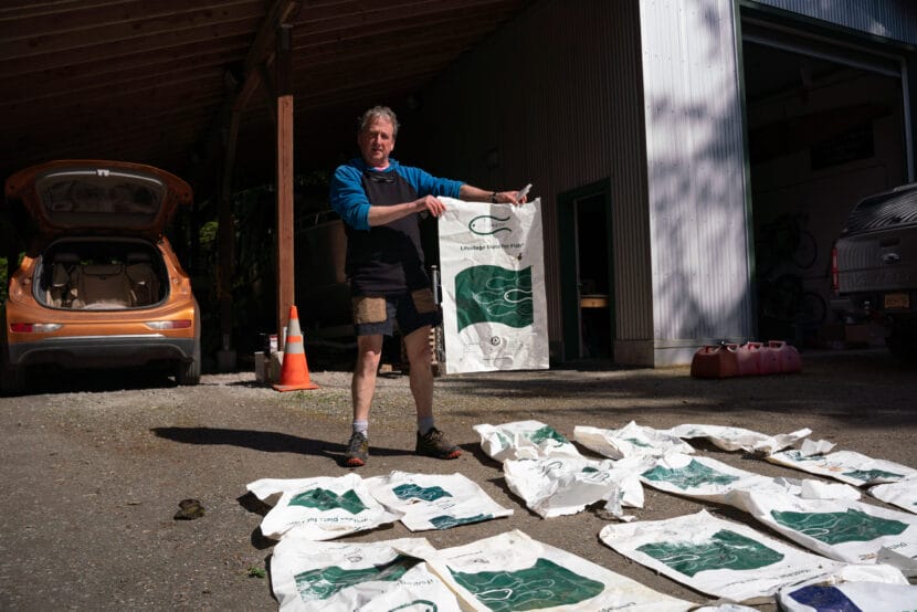 Juneau resident Wayne Carnes holds one of the 54 fish food bags he found around Funter Bay. (Photo by Alix Soliman/KTOO).