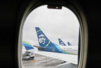 several Alaska Airlines planes parked at airport gates