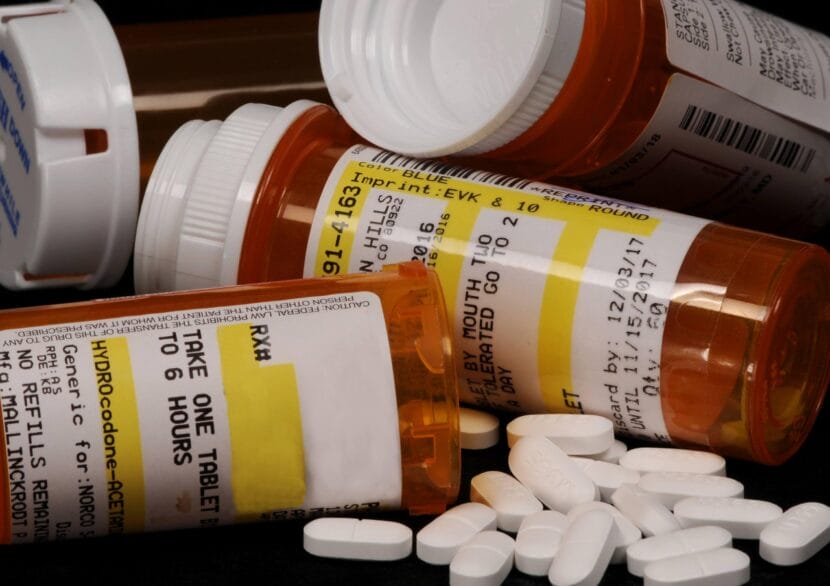 Opioid pills spill out of prescription bottles.