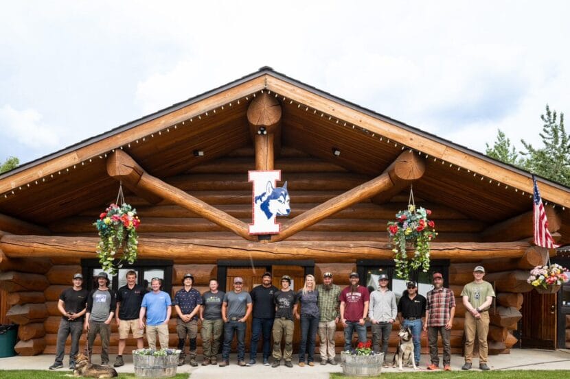 Mushers pose for a photo at the Iditarod Trail Committee's 2026 sign-up event.