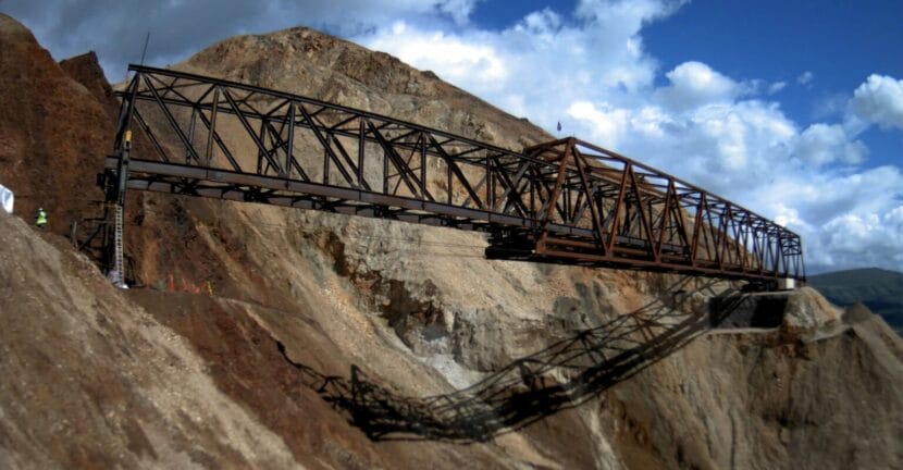 a metal bridge sits in front of a slope