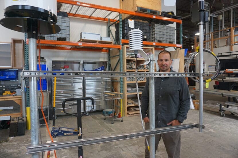 a man stands in a warehouse next to a landslide monitoring device