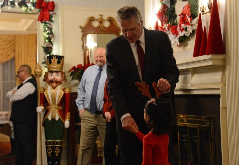 Alaska Gov. Mike Dunleavy greets a child during the governor's annual holiday open house on Tuesday, Dec. 12, 2022 at the Governor's Mansion in Juneau.