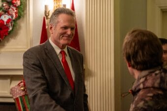 Gov. Mike Dunleavy greets a visitor to his final holiday open house as governor on Dec. 9, 2025.
