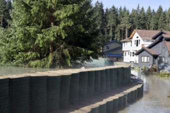 Floodwater seeps through HESCO barriers on Meander way during the glacial outburst flood on Wednesday, Aug. 13, 2025. (Photo by Clarise Larson/KTOO)