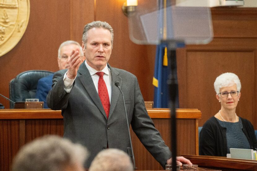 man gestures during speech in legislative chamber
