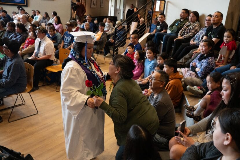 Patty Fox of Kipnuk reaches out to embrace her mother, Shirley Fox, during the graduation's Rose Ceremony (May 18, 2026. Alaska Native Heritage Center). 